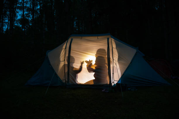 kinderen die schaduwpoppen in een het kamperen tent bij nacht maken - wajang stockfoto's en -beelden