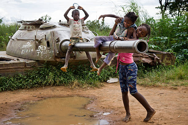 Children play with an abandoned tank. stock photo