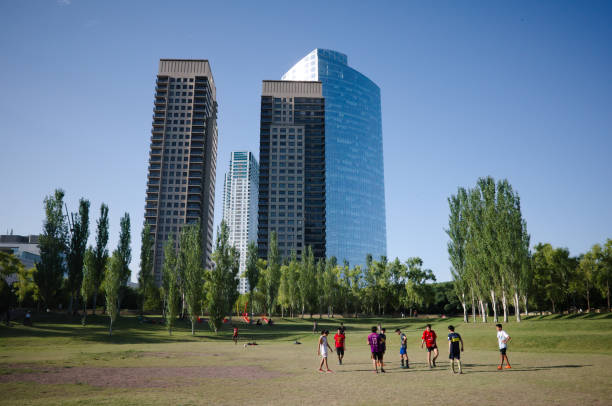 Children playing football in public park. Skyscrapers of Puerto Madero district on background stock photo
