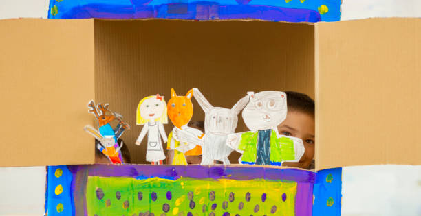 Children playing with hand made puppet dolls in classroom stock photo