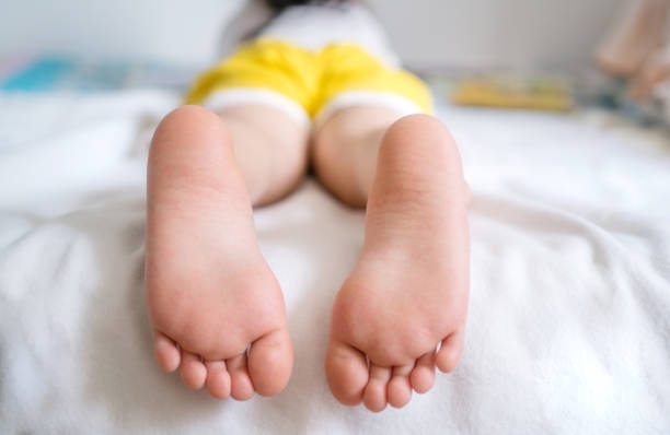 Children read book lie on the bed, big barefoot Children read book lie on the bed, big barefoot asian girls feet stock pictures, royalty-free photos & images