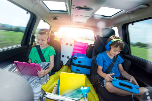 Children relax in the car during a long car journey stock photo