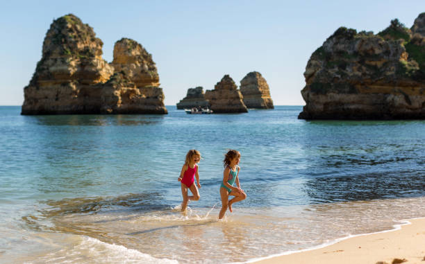 children running at the beach, praia da boneca, lagos, portugal - people portugal imagens e fotografias de stock