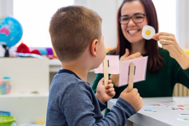 Children speech therapy concept. Preschooler practicing correct pronunciation with a female speech therapist. Children speech therapy concept. Preschooler practicing correct pronunciation with a female speech therapist. healthy tongue picture stock pictures, royalty-free photos & images