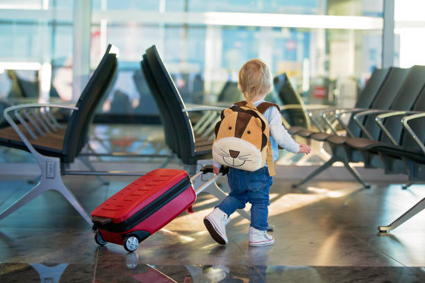 Children, traveling together, waiting at the airport to board the aircraft stock photo