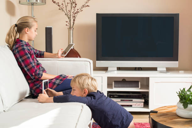 Children using tablet and smartphone in living room stock photo