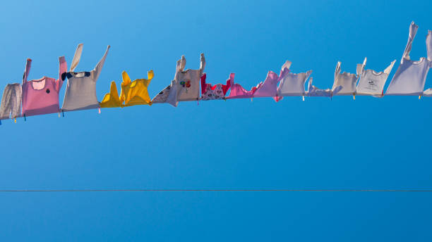 Children With A Rope Stretched To The Sky, Their Colorful Tıny Clothes Flying Freely In The Wind stock photo