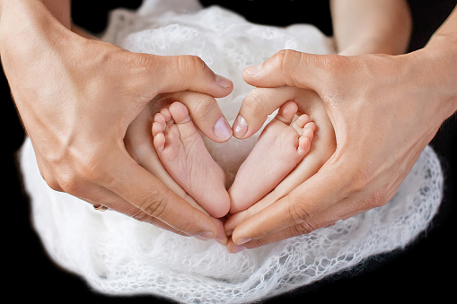 Childrens Feet In Hands Of Mother And Father Stock Photo ...