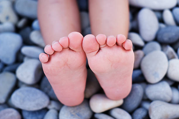 Children's feet on the beach stock photo