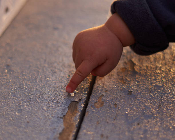 Children's hand pointing A young child's hand pointing at something on a wood board with chipped paint at a playground at dusk under sunset in Calgary, Alberta, Canada in a spring evening peeling off stock pictures, royalty-free photos & images