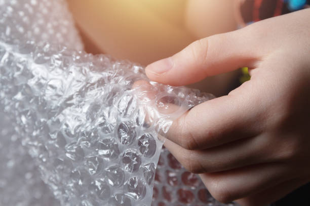 Children's hands popping bubble wrap stock photo