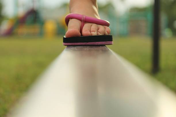 Child's foot on a balance beam stock photo