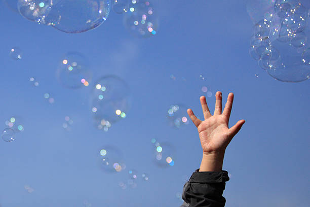 Child's Hand and Bubbles stock photo