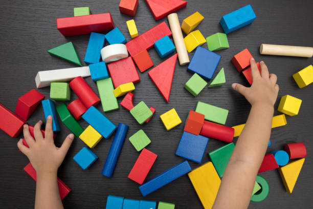 Child's hand close up playing building blocks stock photo