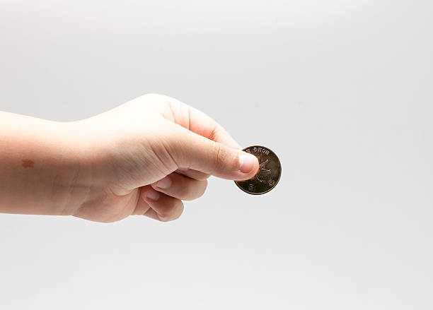 child's hand holding the coin stock photo