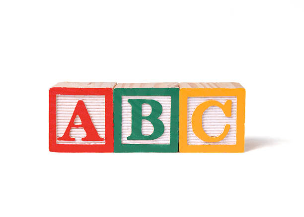 Child's wooden ABC alphabet blocks on white background Child's wooden alphabet blocks in a row alphabetical order stock pictures, royalty-free photos & images