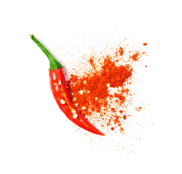 Chili powder spilled out of a cut open chili pepper Chili powder spilled out of a cut open chili pepper cayenne pepper photos stock pictures, royalty-free photos & images