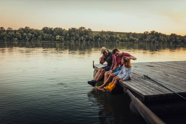 Chill time for this three guys Grandfather, father and grandson sitting on the pontoon and taking a break while fishing lake photos stock pictures, royalty-free photos & images