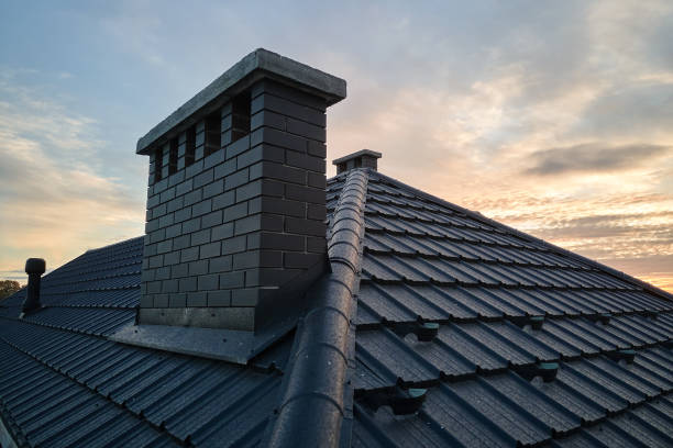 Chimney on house roof top covered with metallic shingles under construction. Tiled covering of building. Real estate development stock photo