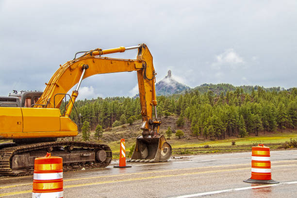 Chimney Rock National Monument, in Colorado USA with large backhoe working on highway and safety cones on drizzly foggy day stock photo