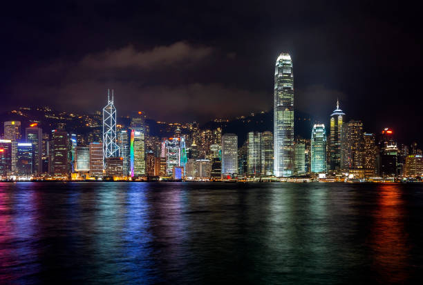 China - Hong Kong - The night panorama view of Hong Kong island Victoria Bay waterfront with international finance center and other skyscrappers with blurred foreground stock photo
