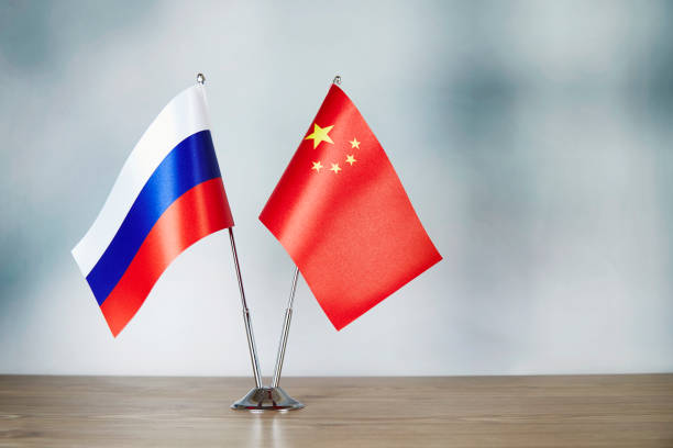 Chinese and Russian flag standing on the table stock photo