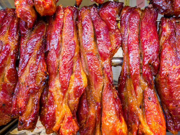 Chinese barbecue pork (char siu) fresh from oven to hanging display stock photo