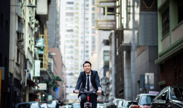 Chinese businessman riding a bike to work stock photo