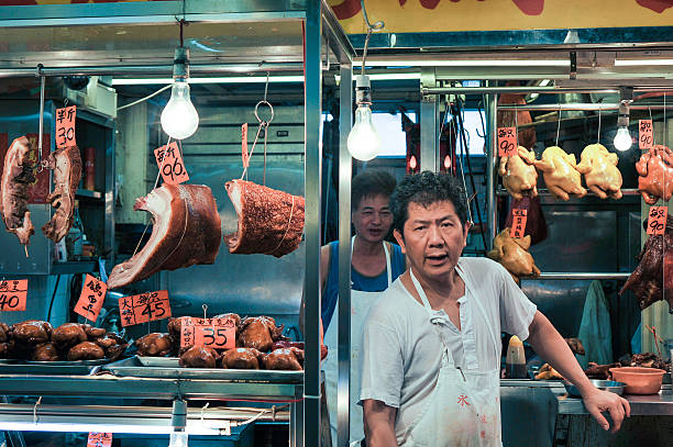 Chinese Butcher at his shop in the market stock photo