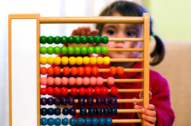 Chinese calculator Little girl learns to count and calculate on a Chinese calculator with colorful beads - Close-up. abacus stock pictures, royalty-free photos & images