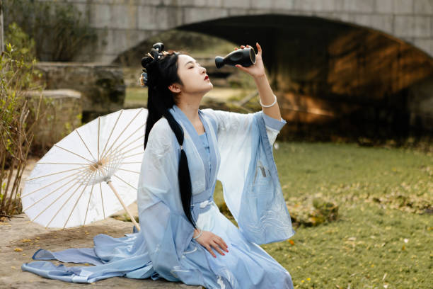 Chinese Han costume beauties drinking by the lake Chinese Han costume beauties drinking by the lake ::::: asian beauties : stock pictures, royalty-free photos & images
