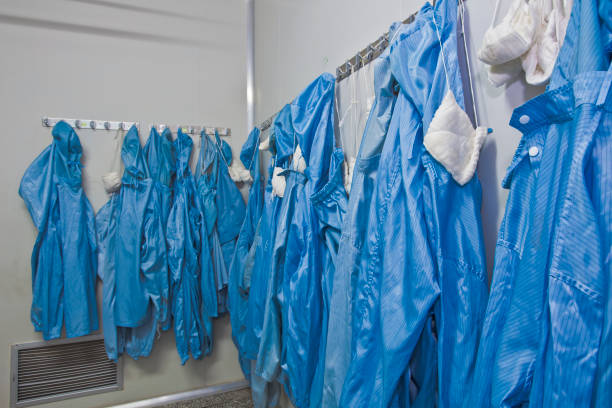 Chinese hospital staffers at the facilities wear gowns, gloves and masks Chinese hospital laboratory working with unrecognizable technician in blue evening gown stock pictures, royalty-free photos & images