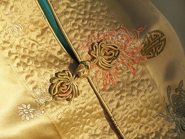 Chinese or Mandarin Gold Silk Jacket Detail with Frog Closure stock photo