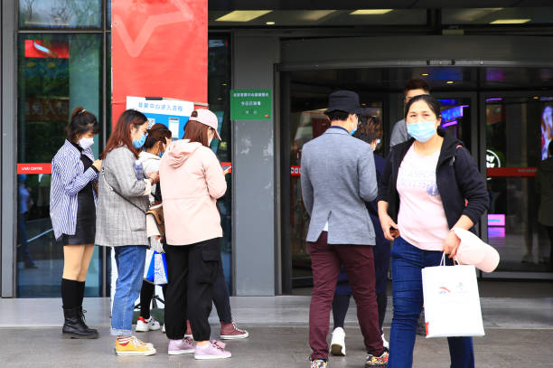 Chinese people wear protective masks scanning code to register information for prevention before go into shopping mall, Beijing is reopening and backing to normal life cautiously stock photo