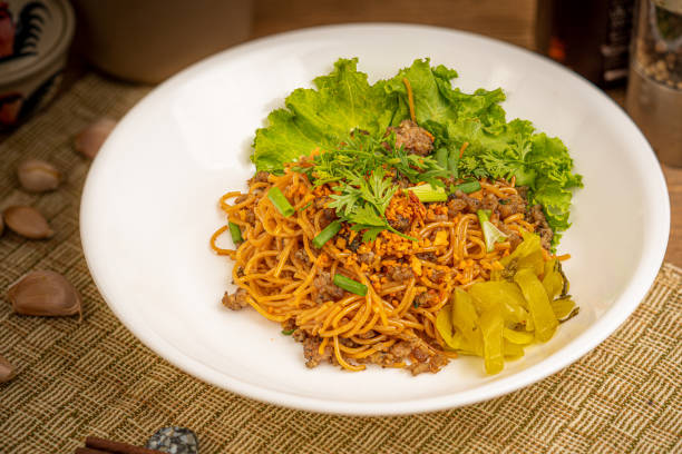 Chinese stir fried noodle with pork on white dish stock photo