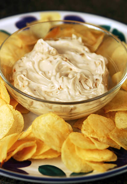 Chips and dip potato chips and onion dip with shallow depth of field (focus on front of dip) shot in studio dipping sauce stock pictures, royalty-free photos & images