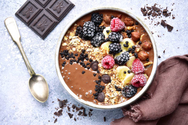 Chocolate banana smoothie bowl with frozen berries stock photo
