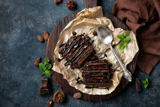 chocolade brownie taart, dessert met noten op donkere achtergrond, direct boven, plat lag - brownie stockfoto's en -beelden