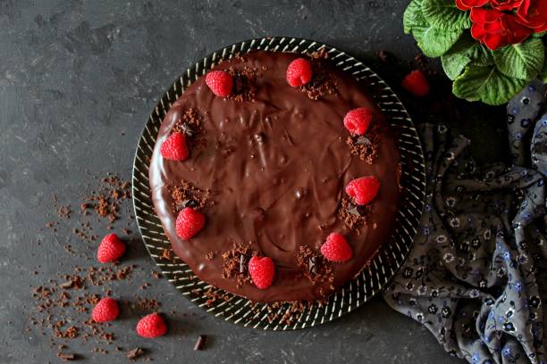 chocolate cake with fruits on a plate over dark background. - bolos de chocolate imagens e fotografias de stock