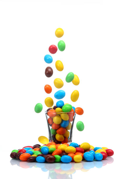 chocolate candies coated with colors chocolate candies coated in colors falling towards a baso pick and mix stock pictures, royalty-free photos & images