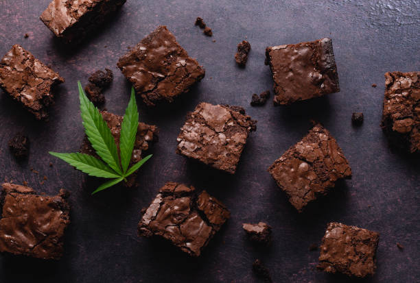 Chocolate cannabis brownies made with CBD infused butter CBD infused chocolate cannabis brownies topped with a marijuana leaf. A delicious dessert and a relaxing after effect. brownie stock pictures, royalty-free photos & images