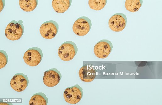 istock Chocolate chip cookies arranged in a pattern on a turquoise  background. Sweet food concept with copy space. 1328135730