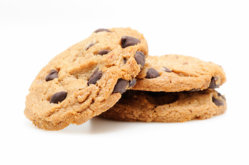 Chocolate chip cookies with pieces of chocolate flying or falling over white background