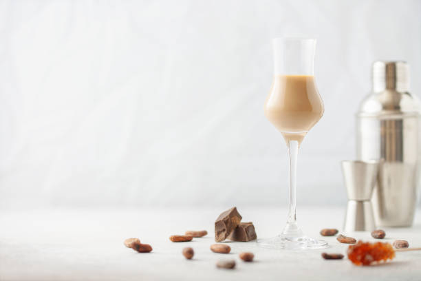 Chocolate cream alcohol liqueur in a glass, pieces of chocolate and cocoa beans. stock photo