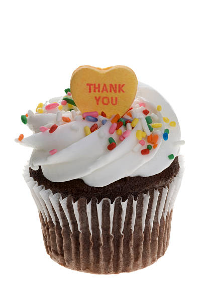 A chocolate cup with white frosting and a thank you heart stock photo