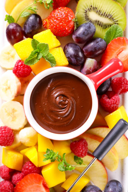 chocolate fondue and fresh fruits stock photo
