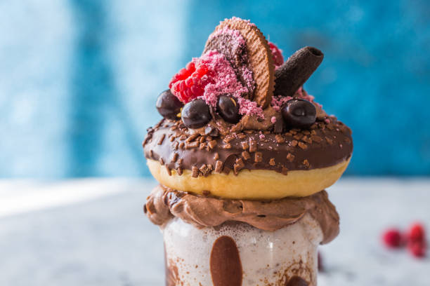 chocolade toegeeflijke exreme milkshake met donut en snoep. gekke freakshake voedseltrend. ruimte kopiëren - freakshake fruit stockfoto's en -beelden