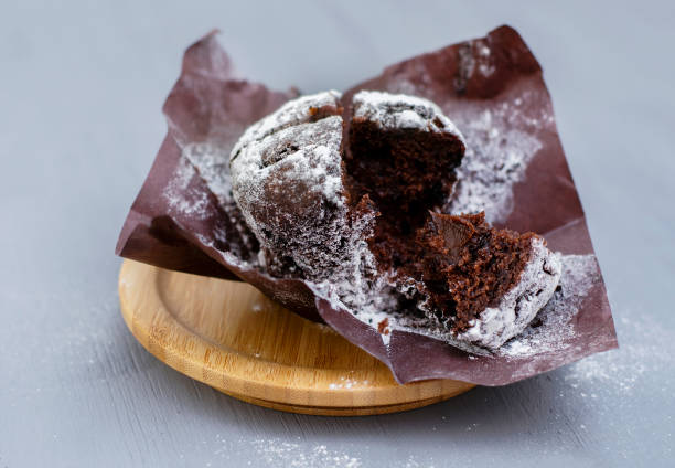 Chocolate muffin with a liquid center and powdered sugar on top on a light background. stock photo