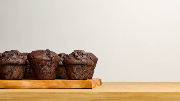 Chocolate muffins on wooden table, with empty copy space. stock photo
