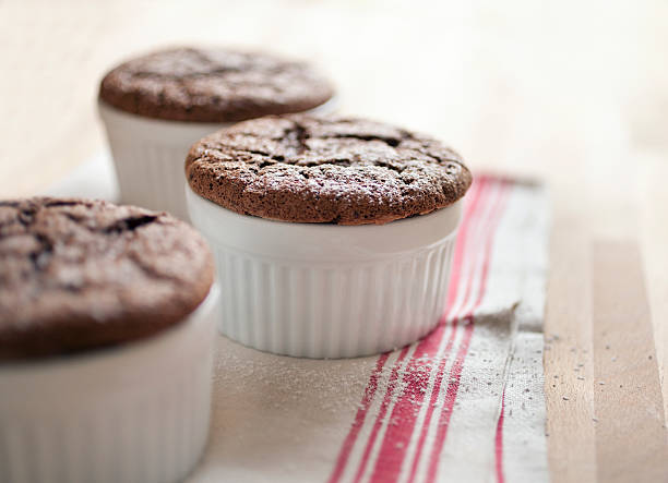 Chocolate souffles Freshly baked chocolate souffles dusted with powdered sugar semi sweet chocolate stock pictures, royalty-free photos & images